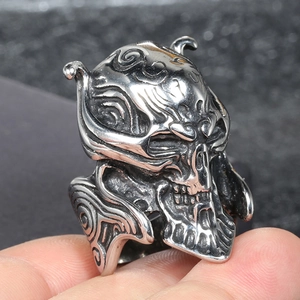 Gros plan détaillé d'une bague tête de mort punk vintage avec des textures en spirale argent