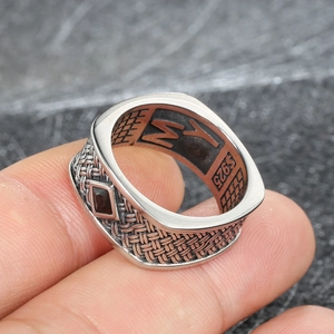 Vue macro d'une bague en argent S925 avec texture tressée et une pierre noire losange