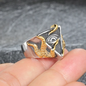 Detailed macro view of punk stainless steel ring with All-Seeing Eye and golden tentacles