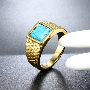 Macro shot of men's gold stainless steel ring with rectangular turquoise stone detail