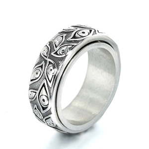 Vintage stainless steel spinner ring with engraved eye patterns on a wide silver band