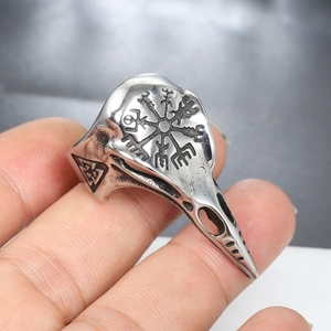 Macro view of vintage stainless steel bird skull ring featuring Viking Vegvisir rune engraving