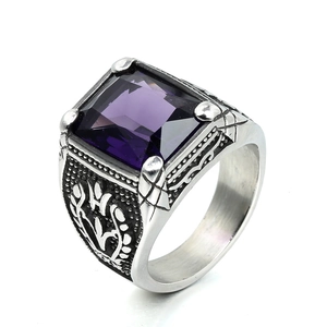 Macro detail of vintage silver steel ring featuring a square purple stone and fleur-de-lis carving