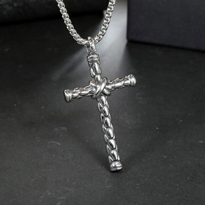 Macro del ciondolo a croce in acciaio inossidabile argento con trama intrecciata su nero