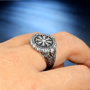 Macro shot of Viking compass signet ring with skulls and Celtic knots on finger