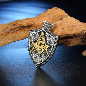 Detail shot of Freemasonry shield pendant with gold compass logo on wood block