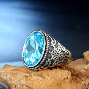 Macro view of vintage stainless steel ring featuring large oval blue gemstone and carvings