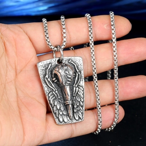 Collier vintage en acier titane oxydé avec pendentif bouclier corbeau tenu dans la main