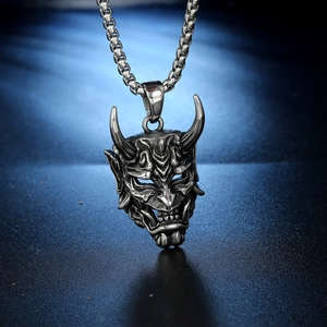 Detailed close-up of a silver Hannya mask pendant with a box chain in punk style