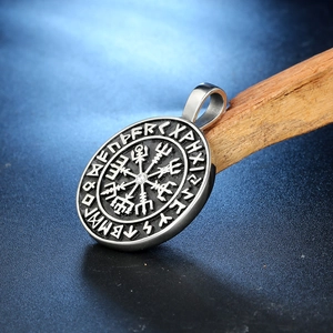 Vintage stainless steel Viking Vegvisir compass pendant with embossed runes on dark wood