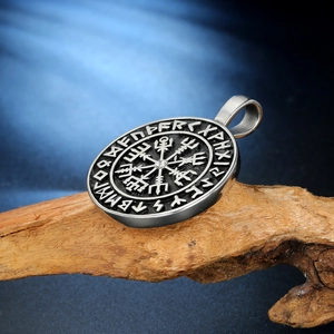 Macro detail of Viking Vegvisir compass pendant with runes and center crystal stone