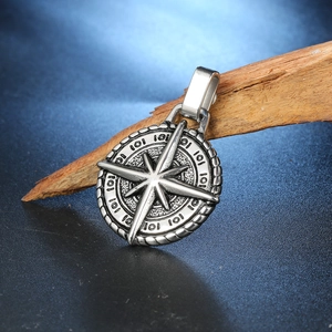 Vue détaillée du pendentif boussole vintage en acier inoxydable avec texture vieillie