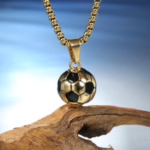 Vue macro du pendentif ballon de foot or et noir avec une chaîne à mailles carrées