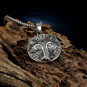 Vintage Viking wolf head amulet necklace in stainless steel on a rustic wood background