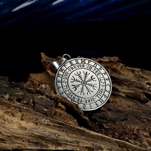 Macro detail of silver stainless steel Viking pendant with Runes on rustic wood