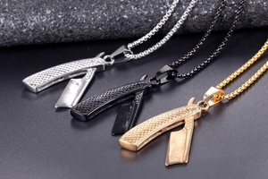 Detailansicht der Rasierklingen-Anhänger in Silber, Schwarz und Gold an einer Boxkette