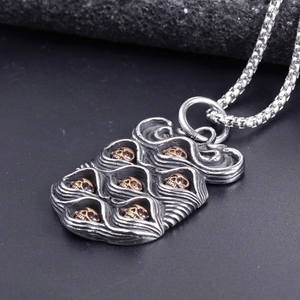 Punk style stainless steel necklace featuring a textured pendant with gold skull accents