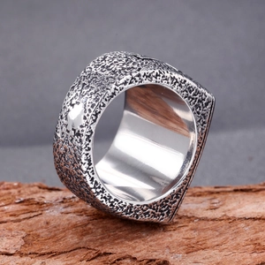 Macro shot of vintage silver steel ring with hammered rock texture and polished inner band