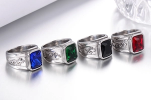 Detailed view of four stainless steel men's rings with dragon relief and gemstone