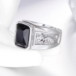 Macro detail of men's stainless steel dragon ring featuring a rectangular black gemstone
