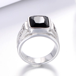 Close-up of men's stainless steel ring with square black gemstone and carved details