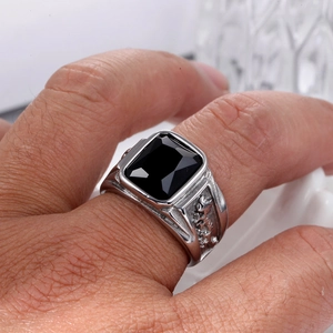 Macro shot of men's silver ring featuring black gemstone and leopard relief carvings