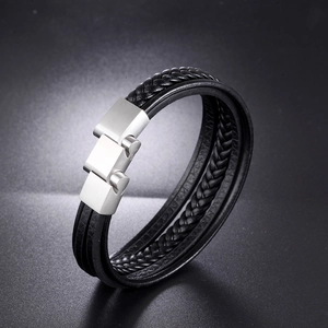 Détail du bracelet multicouche en cuir tressé noir avec boucle en métal brossé