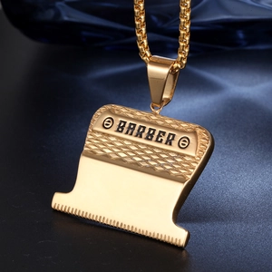 Gold barber clipper pendant necklace with box chain and barber lettering on blue velvet