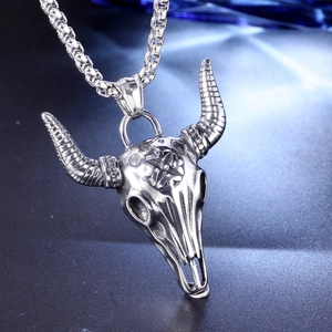 Close-up of vintage punk bull skull pendant with engraved cross on a box chain