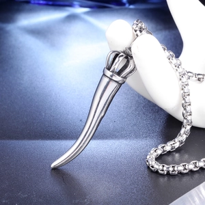 Macro shot of silver chili pendant necklace with vintage crown detail on hand model