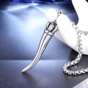 Silver horn pendant necklace with crown detail displayed on a hand model