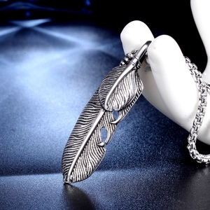 Vintage silver feather pendant necklace with detailed textures in punk bohemian style