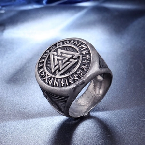 Détail macro d'une bague viking en acier avec le symbole Valknut et des runes nordiques