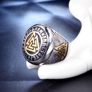 Détail macro d'une bague Valknut viking avec relief doré et runes gravées sur l'acier