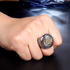 Détail de la bague Viking Valknut avec relief doré et runes gravées sur acier vintage