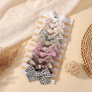 Set of 10 elastic nylon baby headbands with assorted patterns and boutique hair bows