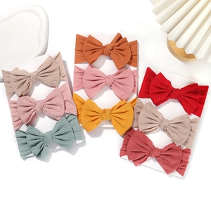 Set of 8 baby bow headbands in various colors with soft elastic ribbed fabric texture