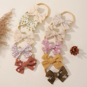 Detail of 10-piece baby bow headband set with assorted floral patterns on nylon bands