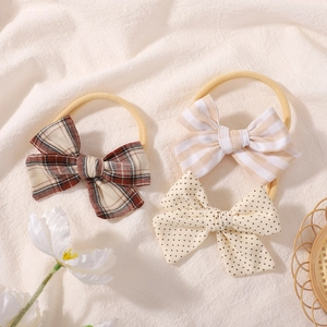 Detailed view of elastic nylon baby headbands with plaid, striped, and polka dot bow designs