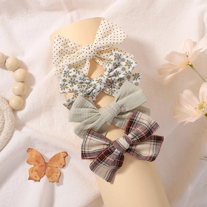 Set of 4 elastic nylon baby headbands with floral, polka dot, solid green, and plaid bows