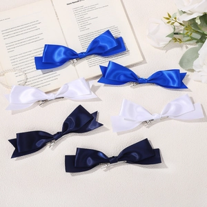 Lot de 6 barrettes à nœuds en satin pour filles en bleu et blanc sur un livre