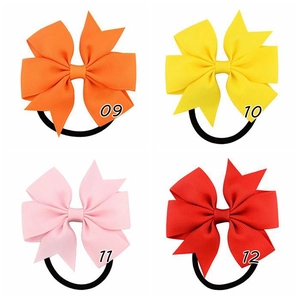 Dettaglio di quattro elastici per capelli con fiocco in grosgrain in arancione, giallo e rosa
