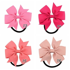 Dettaglio di quattro elastici per capelli in nastro grosgrain a coste in varie tonalità rosa