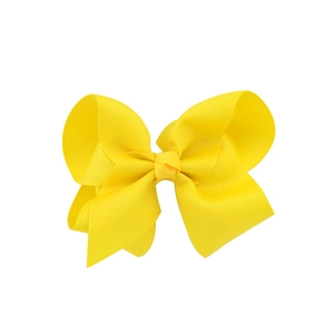 Detalle de lazo para el pelo en cinta de grosgrain amarillo con capas y nudo central