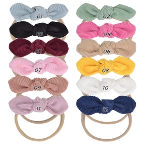 Detail view of 12 multi-color corduroy bow headbands with elastic nylon bands for babies