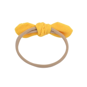 Bright yellow corduroy bow headband on a soft nylon hair tie for babies and kids