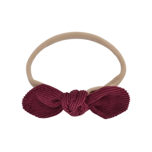 Detail of burgundy corduroy bow with high-elastic nylon band for infant hair accessories