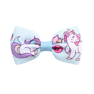 Dettaglio del fiocco in gros-grain blu con motivi di unicorno e stelle per bambini