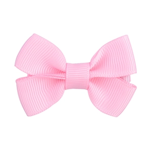 Dettaglio di un fermaglio per capelli in gros-grain rosa con texture a coste per bambine