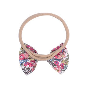 Gros plan détaillé du bandeau bébé avec nœud floral et élastique en nylon pour nourrissons